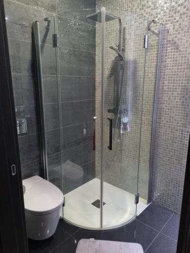 a bathroom with a glass shower with a toilet at My 2and house in Baleal