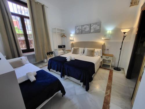 a hotel room with two beds and a window at Casona de San Andrés in Seville
