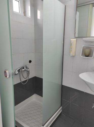 a bathroom with a shower and a sink at Filoxenia Beach Hotel in Rethymno Town