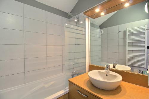 La salle de bains blanche est pourvue d'un lavabo et d'une douche. dans l'établissement SAINTE-FOY STATION - APPARTEMENT 6 PERSONNES - SKIS AUX PIEDS, à Sainte-Foy-Tarentaise