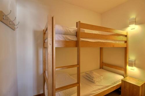 a couple of bunk beds in a room at SAINTE-FOY STATION - APPARTEMENT 6 PERSONNES - SKIS AUX PIEDS in Sainte-Foy-Tarentaise