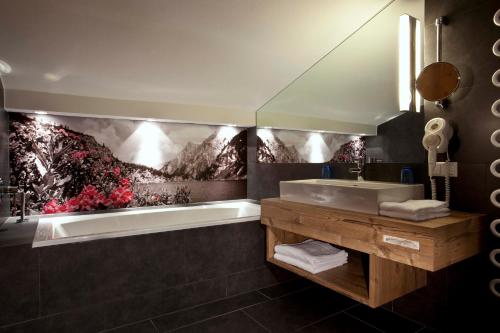 een badkamer met een bad en een wastafel bij Sonnenseite Filzmoos in Filzmoos