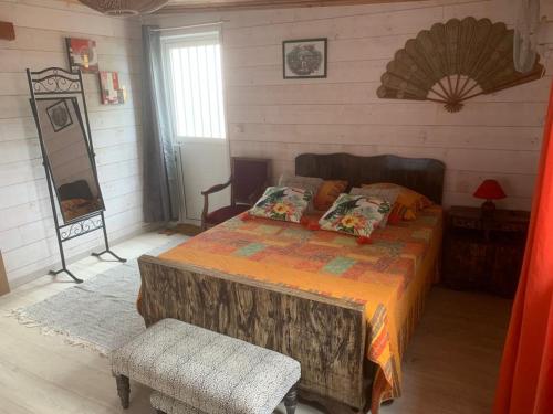 ein Schlafzimmer mit einem Bett und einem Stuhl in einem Zimmer in der Unterkunft Là Haut-Lé Beau in Le Lambert