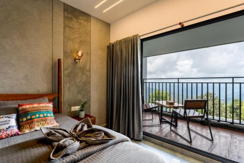 a bedroom with a balcony with a bed and a large window at K Mansion in Munnar