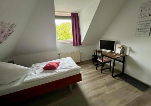 a bedroom with a bed and a desk with a computer at Hotel Vogt in Bad Driburg