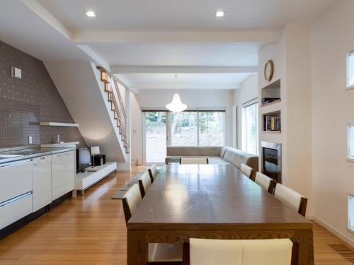 a kitchen and dining room with a long table and chairs at Baw Baw Sansou in Kutchan
