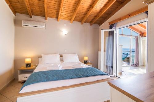 a bedroom with a large bed and a balcony at Agios Gordios Ammos House in Agios Gordios