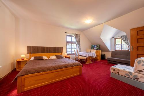 a bedroom with a bed and a table in it at Penzión Zemianska kúria in Dolný Kubín