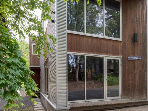 a house with glass windows on the side of it at Baw Baw Sansou in Kutchan