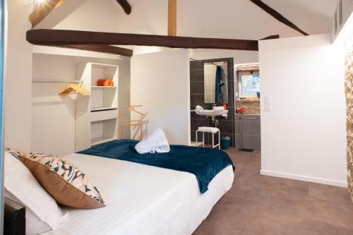 a bedroom with a large white bed in a room at Le Moulin du Porteil in Campagne