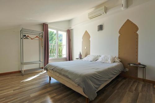 a bedroom with a large bed and a window at Auberge les Galets in Peyruis