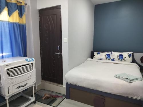 a small bedroom with a bed and a air conditioner at Hotel Homestay Inn in Thimi