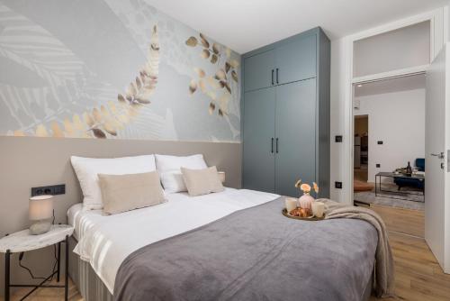 a bedroom with a large white bed with a table at Cosy&Lux on main square, Korzo Rijeka in Rijeka