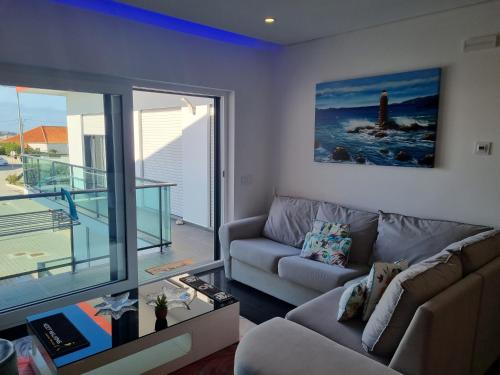 a living room with a couch and a view of a lighthouse at My 2and house in Baleal