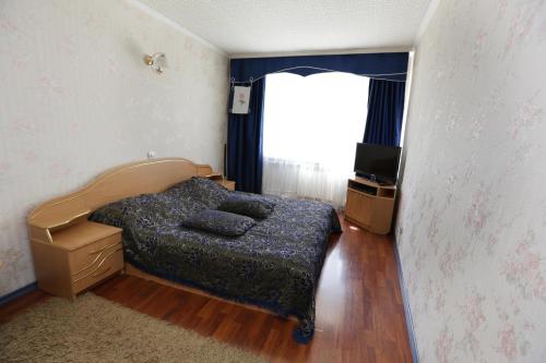 - une chambre avec un lit et une fenêtre dans l'établissement Катюша, à Petropavlovsk-Kamtchatski