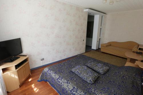 - une chambre avec un lit et une télévision à écran plat dans l'établissement Катюша, à Petropavlovsk-Kamtchatski