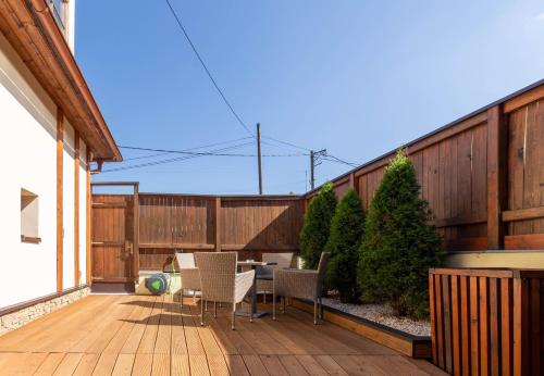a patio with a table and chairs on a wooden deck at Penzión Zemianska kúria in Dolný Kubín
