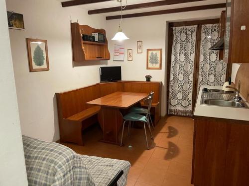 Appartamenti Miriam في باسو ديل تونالي: مطبخ مع طاولة خشبية ومغسلة