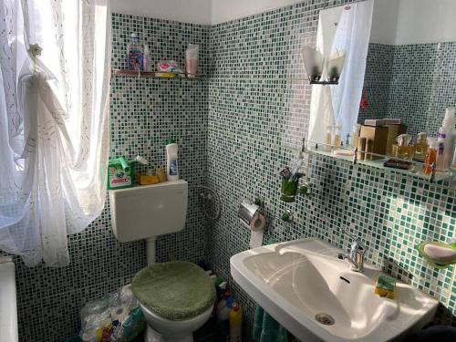 a bathroom with a sink and a toilet and a mirror at Casa- viata la tara in Bucureşci