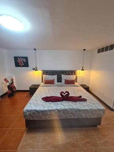 a bedroom with a bed with a bow on it at Happy Beach Jomtien Guesthouse in Jomtien Beach