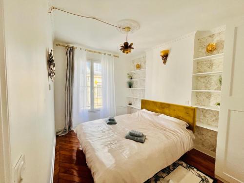 une chambre avec un lit dans une pièce aux murs blancs dans l'établissement Paris rare pearl 5e Notre Dame Saint Michel, à Paris