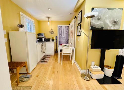 a living room with yellow walls and a flat screen tv at Private Guest Suite in Little Italy - King Bed - Free Parking - Central Location in Vancouver
