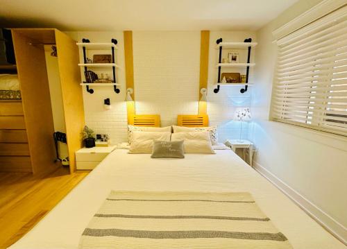 a bedroom with a large white bed with yellow accents at Private Guest Suite in Little Italy - King Bed - Free Parking - Central Location in Vancouver