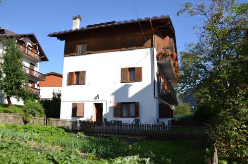 a white house with a wooden roof at Casa Da Rin Elena in Auronzo di Cadore