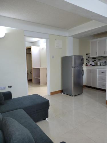 a living room with a couch and a refrigerator at KanXio's Apartment in Pointe Michel