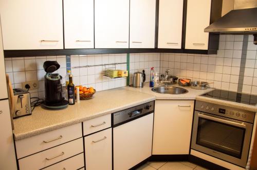 a kitchen with white cabinets and a sink at Private doublebed Room with balcony in shared house in Dornbirn