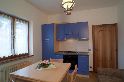 a kitchen with blue cabinets and a table at Casa Da Rin Emma in Auronzo di Cadore