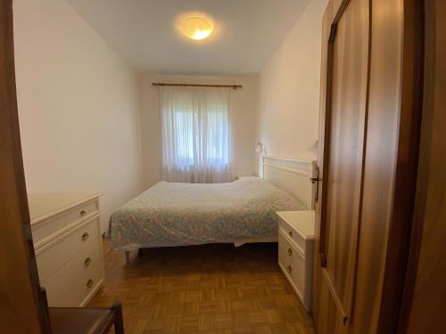 a small bedroom with a bed and a window at Casa Da Rin Emma in Auronzo di Cadore