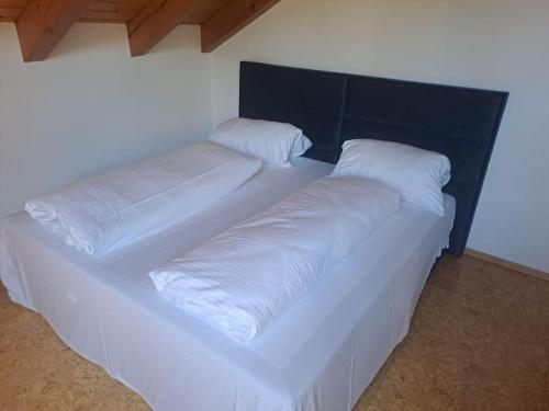 ein großes weißes Bett mit zwei Kissen darauf in der Unterkunft Theox No 12 I 5 Personen I Bibliothek I Badwanne in Heppenheim an der Bergstrasse