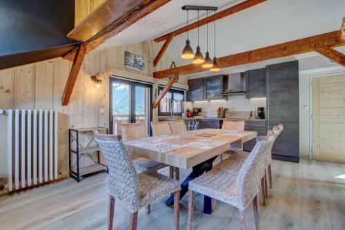 une cuisine et une salle à manger avec une table et des chaises en bois dans l'établissement Les Prodains Appartement 4 à 6 personnes à 100m de l'office de tourisme, à Morzine
