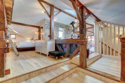 une chambre avec un lit et une chambre avec des poutres en bois dans l'établissement Les Prodains Appartement 4 à 6 personnes à 100m de l'office de tourisme, à Morzine