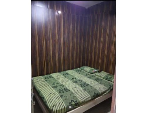 a bed in a room with a wooden wall at Harkishan Lodge, Sambalpur, Odisha in Sambalpur