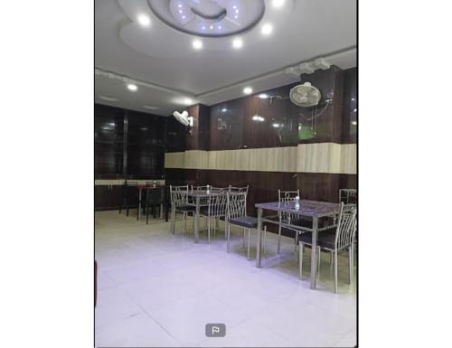 a dining room with tables and chairs and a clock on the ceiling at Harkishan Lodge, Sambalpur, Odisha in Sambalpur