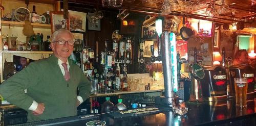 a man standing behind a bar in a pub at Kingfisher Lodge & Pub in Castleconnell