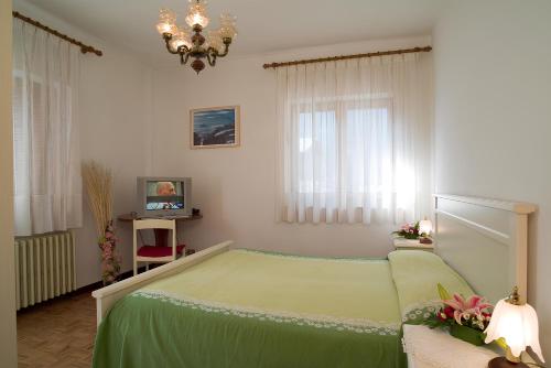 ein Schlafzimmer mit einem grünen Bett und einem Kronleuchter in der Unterkunft Casa Da Rin Giulia in Auronzo di Cadore