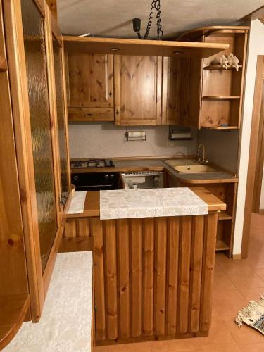 a kitchen with wooden cabinets and a counter top at Appartamenti Miriam in Passo del Tonale