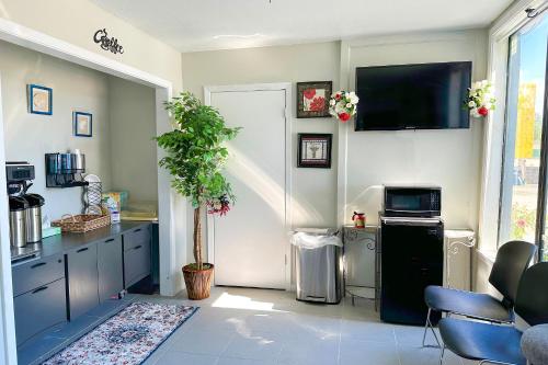 een keuken met een koelkast en een tv aan de muur bij Paradise Inn By OYO Hattiesburg North in Hattiesburg