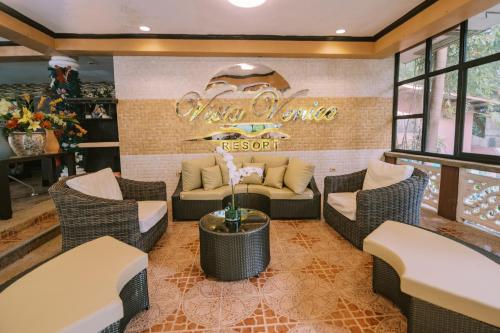 a restaurant with a couch and chairs in a room at Vista Venice Resort in Morong