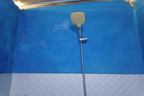 a microphone in the corner of a blue wall at OYO 93121 Abi Bungalow & Hostel in Pawenang