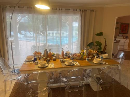a dining room table with chairs and food on it at Chambres d'Hôtes Villa La Louisiane in Arès