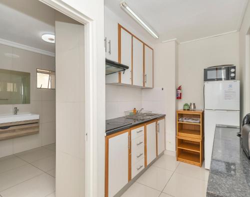 a kitchen with a sink and a refrigerator at Ocean Way Villas - Self Catering in Cape Town