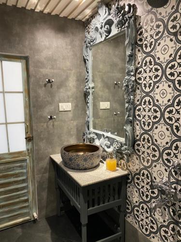 een badkamer met een wastafel en een spiegel aan een muur bij S2 Beach Cottages in Morjim