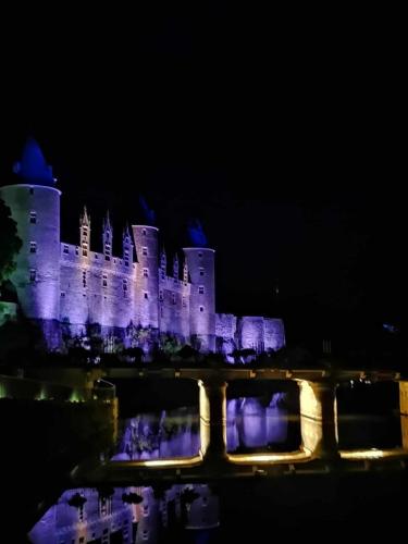 a castle lit up at night with purple lights at La Lézardière in Pleugriffet