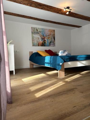 um quarto com uma cama com um cobertor azul em Villa Waldulm em Kappelrodeck