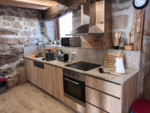 a kitchen with a sink and a stove top oven at Casa da Marquinhas - Turismo Rural in Lama de Ouriço