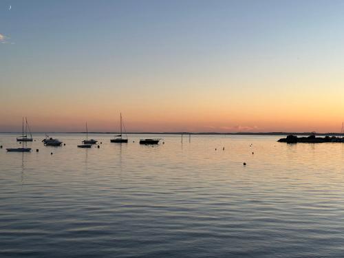 a group of boats in the water at sunset at Chambres d'Hôtes Villa La Louisiane in Arès